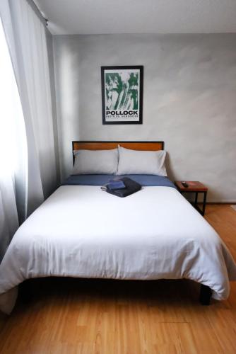 a bedroom with a large bed with white sheets at Compact Studio Apartment Casa Icacos Apt 6 in Mexico City