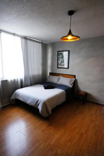a bedroom with a bed and a large window at Compact Studio Apartment Casa Icacos Apt 6 in Mexico City
