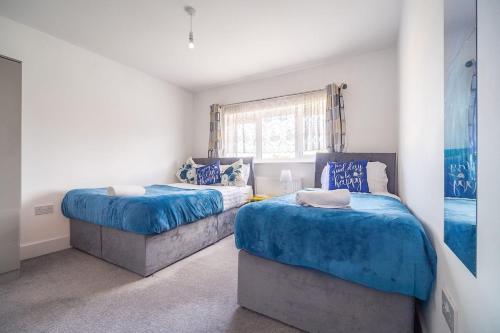 a bedroom with two beds and a window at 3 Bedroom Spacious Bella Range Homes in Hornchurch