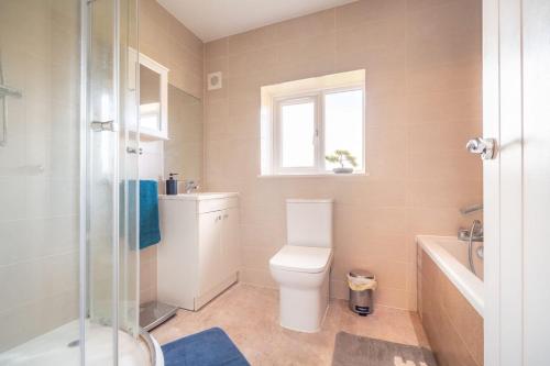 a bathroom with a toilet and a sink and a window at 3 Bedroom Spacious Bella Range Homes in Hornchurch