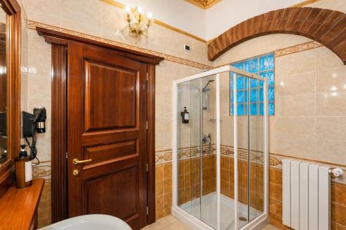 a bathroom with a shower and a wooden door at Euro Hotel Iglesias in Iglesias
