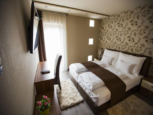 a bedroom with a large bed and a window at Pole Position Beach Hotel in Balatonszárszó