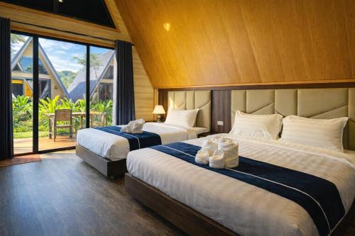 a hotel room with two beds and a large window at Nature Resort Vangvieng in Vang Vieng
