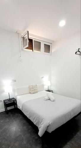 a bedroom with a large white bed with two lamps at AYZ Ulises - Auto check-in property in Madrid