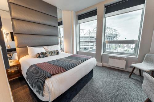 a hotel room with a bed and a large window at Sandman Signature Newcastle Hotel in Newcastle upon Tyne