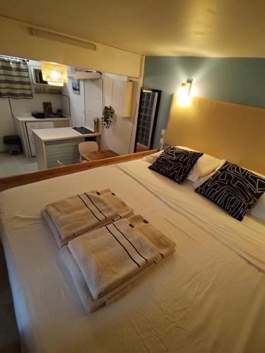 a large white bed with two towels on it at Lagoon Studio Appartement in Fort-de-France