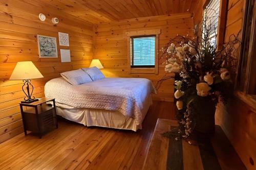 a bedroom with a bed in a wooden cabin at Charlie Long Cabin - Active Heroes in Shepherdsville
