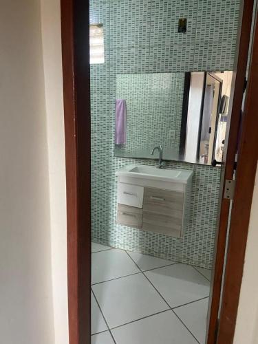 a bathroom with a sink and a mirror at Casa temporada in Arraial do Cabo