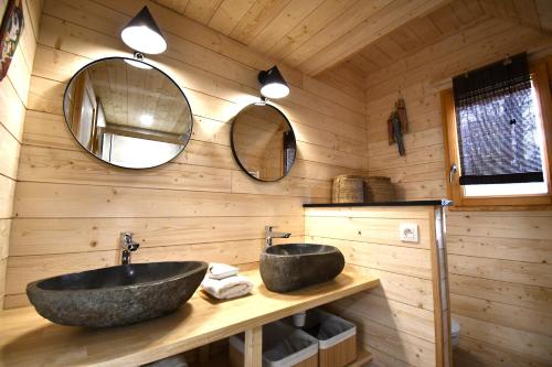 a bathroom with two sinks and two mirrors at Les 7 Montagnes in Lourdes