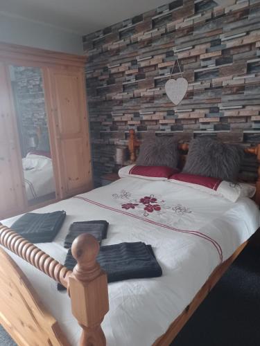 a bedroom with a large bed with a brick wall at Masons Nook 292 Mansfield Road NG174HR in Skegby