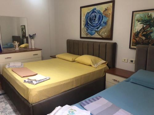 a bedroom with two beds and a blue flower painting at Center Luxury Apartment in Tirana