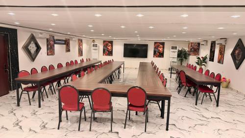 Una sala de conferencias con una mesa larga y sillas rojas. en Hotel Bergmann, 