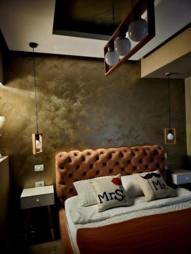 a bedroom with a brown bed with pillows on it at Laci Lak Premium apartment in Oradea