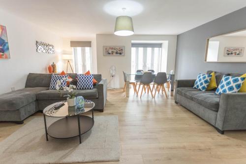 a living room with two couches and a table at Bright 2 Bed Apartments in Marston Oxford, Free Parking, OX3 Near John Radcliffe Hospitals & University Parks in Oxford