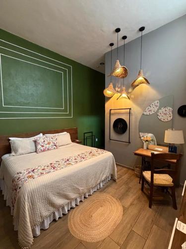 a bedroom with a bed with a green wall at PASEO REAL HOTEL BOUTIQUE in Uruapan del Progreso