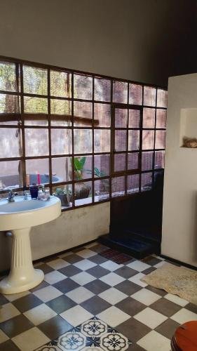 a bathroom with a sink in a room with windows at Los Patios Haras El Malacate in A. de la Cruz