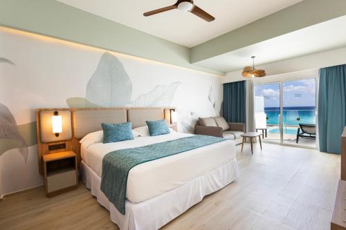 a hotel room with a bed and a view of the ocean at Riu Ventura - All Inclusive in Cancún