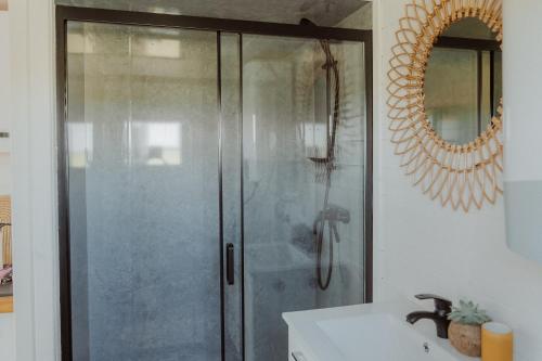 a shower with a glass door in a bathroom at Tiny Bali spa house in Menaldum