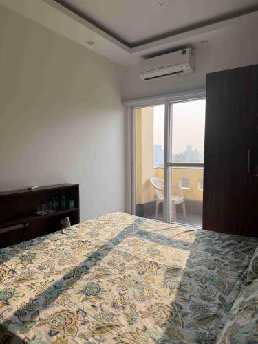 a bedroom with a bed and a large window at Pacation Home Stay in Noida