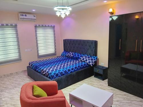 a bedroom with a bed and a chair at Dipo Apartments in Badore