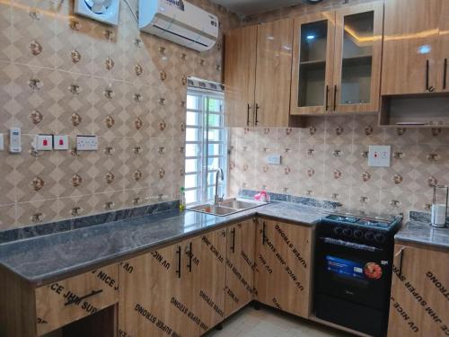 a kitchen with wooden cabinets and a sink at Dipo Apartments in Badore