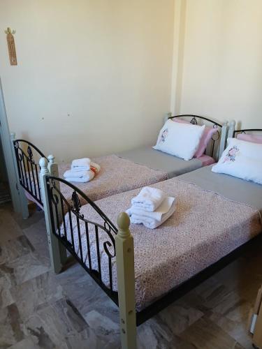 two twin beds in a room with towels on them at Livanos Apartments in Neapoli Voion