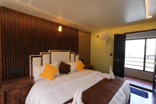 a bedroom with a large white bed with yellow pillows at My Trip Houseboats in Alleppey