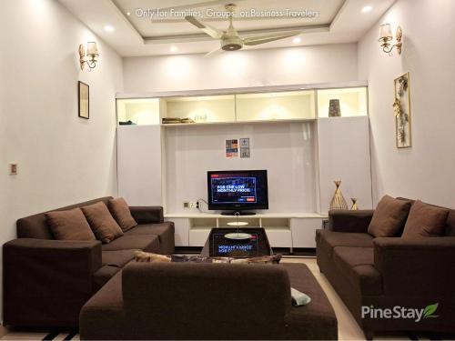 a living room with two couches and a tv at Pine Stay Premium 3 Bedroom Furnished Family Home in Lahore