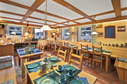 a dining room with wooden tables and chairs at Pension and Apartments MONIKA in Špindlerův Mlýn