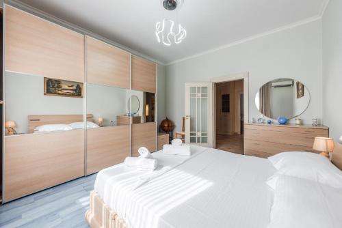 a bedroom with a large white bed and a mirror at The Old-Clock Apartment by PikHost in Shkodër