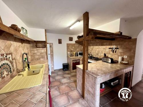a kitchen with a sink and a tub in a room at Domaine de la calm in Villardonnel