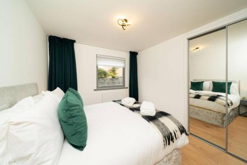 a bedroom with a white bed and a mirror at Ellaburn in Barry