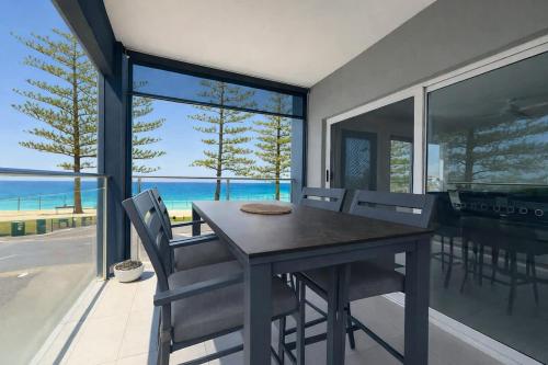 a dining room with a table and chairs and the ocean at Golden Beach Oceanfront 3BR in Golden Beach