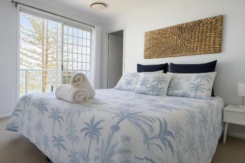 a bedroom with a bed with a stuffed animal on it at Golden Beach Oceanfront 3BR in Golden Beach