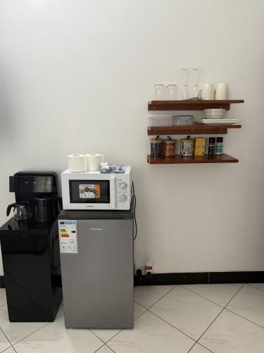a microwave sitting on top of a refrigerator at Dana's Room in Dar es Salaam