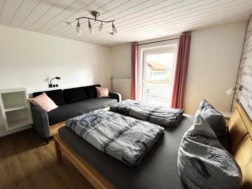 a living room with a couch and a bed at FeWo Beim Huber in Hopferau