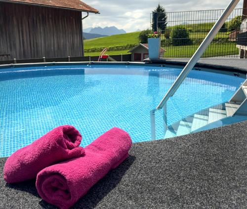 a pair of towels sitting next to a swimming pool at FeWo Beim Huber in Hopferau