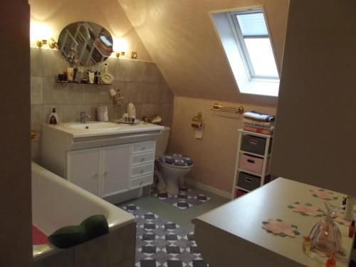 a bathroom with a sink and a toilet at Chambres d'hôtes La Poudrière in Argentan