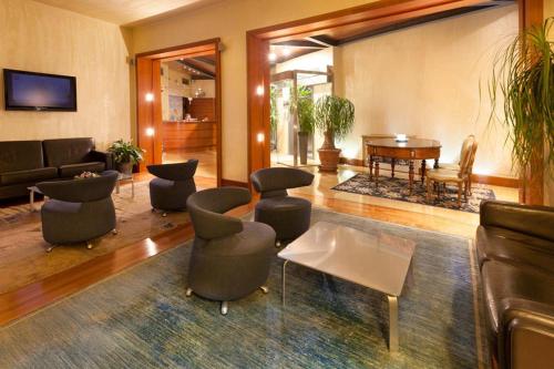 a living room with couches and chairs and a table at B&B HOTEL Imperia Rossini al Teatro in Imperia