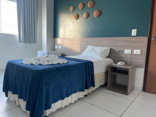 a bedroom with a bed with a blue blanket at Hotel Center Vitoria in Vitória de Santo Antão