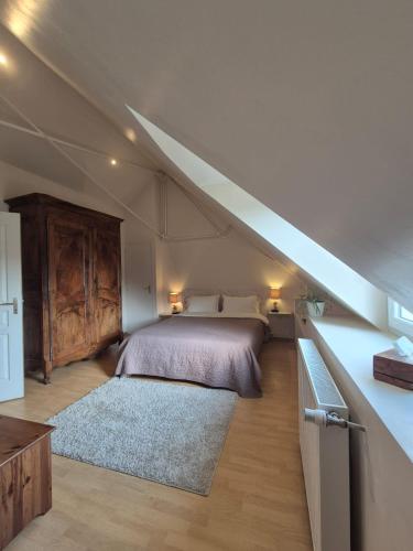 a attic bedroom with a bed and a staircase at la longère angevine in Juigné-sur-Loire