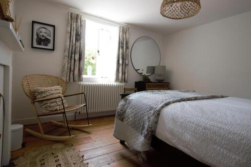 a bedroom with a bed and a chair and a mirror at 2 Bed in Swanage oc-wy460 in Swanage