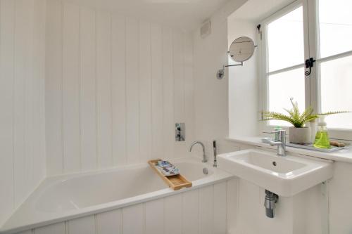 a white bathroom with a sink and a bath tub at 2 Bed in Swanage oc-wy460 in Swanage