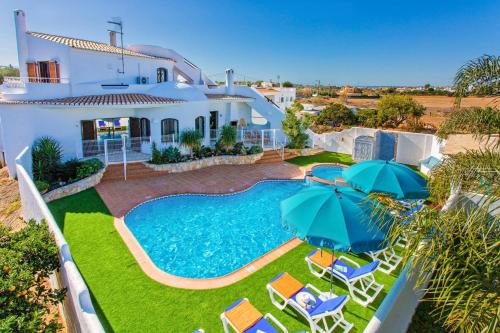 an aerial view of a house with a swimming pool and umbrellas at Villa Casa do Laguinho by Villa Plus in Albufeira