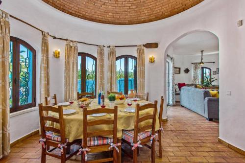 a dining room with a table and some windows at Villa Casa do Laguinho by Villa Plus in Albufeira