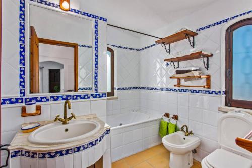 a bathroom with a sink and a tub and a toilet at Villa Casa do Laguinho by Villa Plus in Albufeira