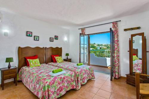 a bedroom with a large bed and a balcony at Villa Casa do Laguinho by Villa Plus in Albufeira