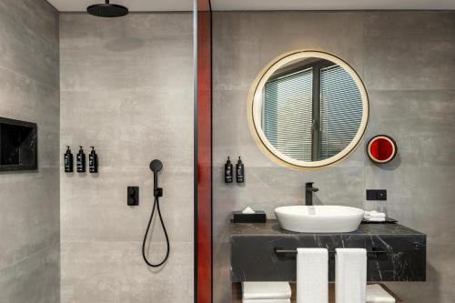 a bathroom with a sink and a mirror at Radisson RED Izmir Point Bornova in İzmir