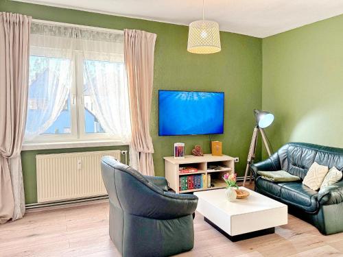 a living room with two chairs and a tv at GurkenLoft in Lübbenau