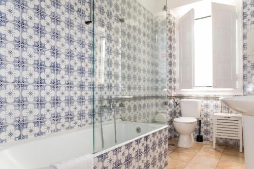 a bathroom with a tub and a toilet and a sink at WOT Lodge Soul in Ericeira